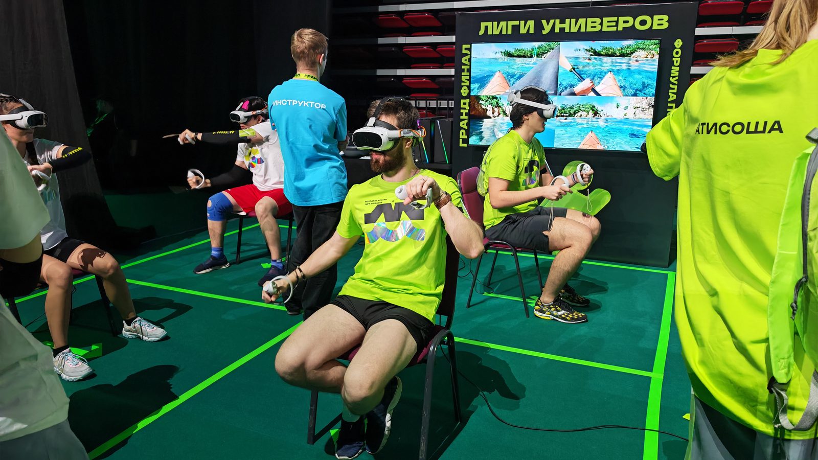 Двое участников в VR-шлемах гребут в соревновании по гонкам на каяках