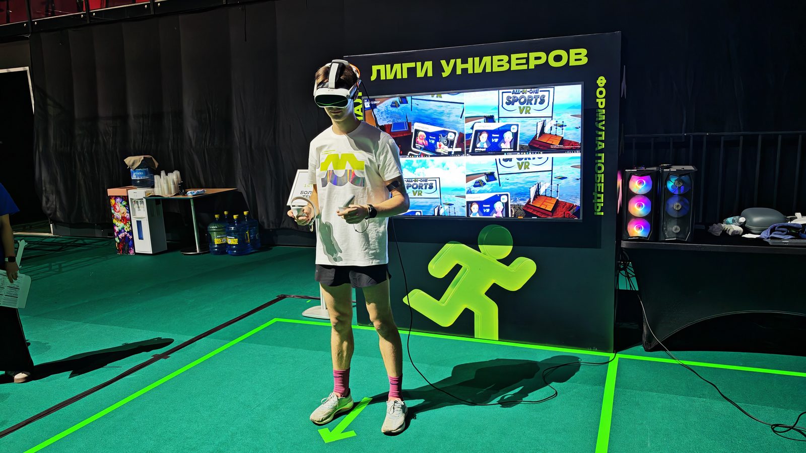 Участница в VR-шлеме на спортивной зоне, за спиной экран с логотипом «Лиги Универов»
