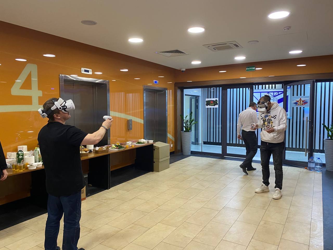VR-зона в холле бизнес-центра рядом с фуршетным столом, гость играет