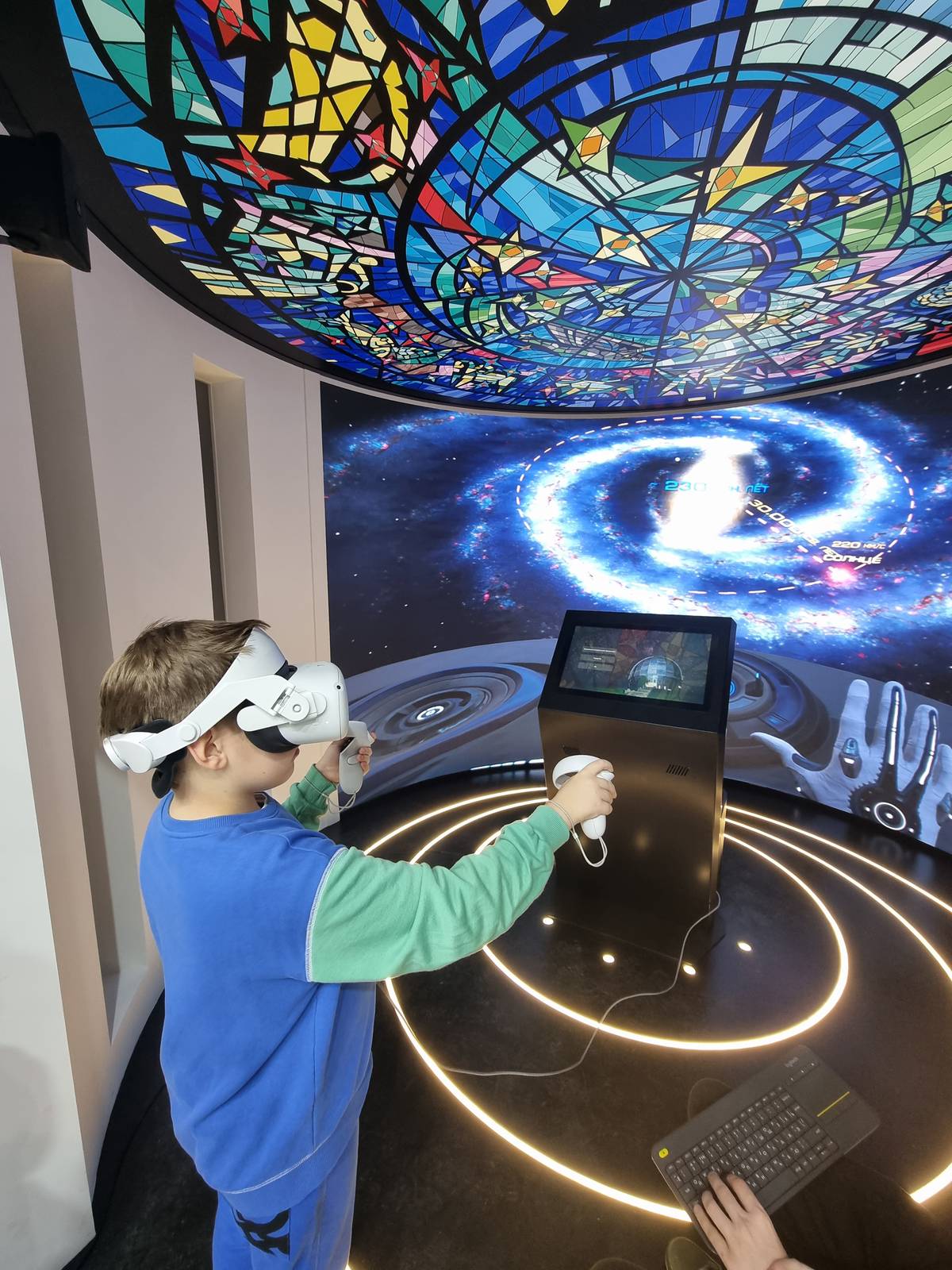 VR-зона в планетарии: посетитель в шлеме у интерактивной стойки под куполом