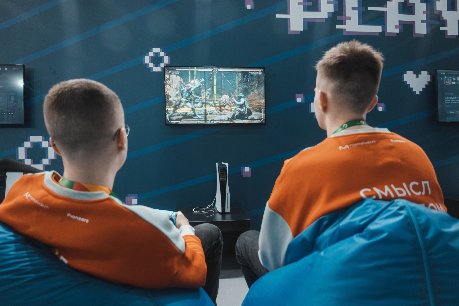 Консольная зона турнира: двое играют в файтинг на PlayStation 5