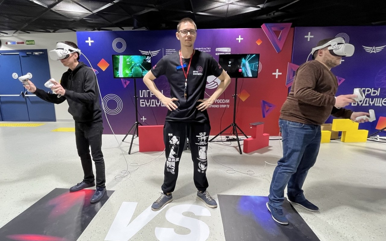 Двое гостей играют в VR одновременно, между ними оператор, игра идёт на двух экранах