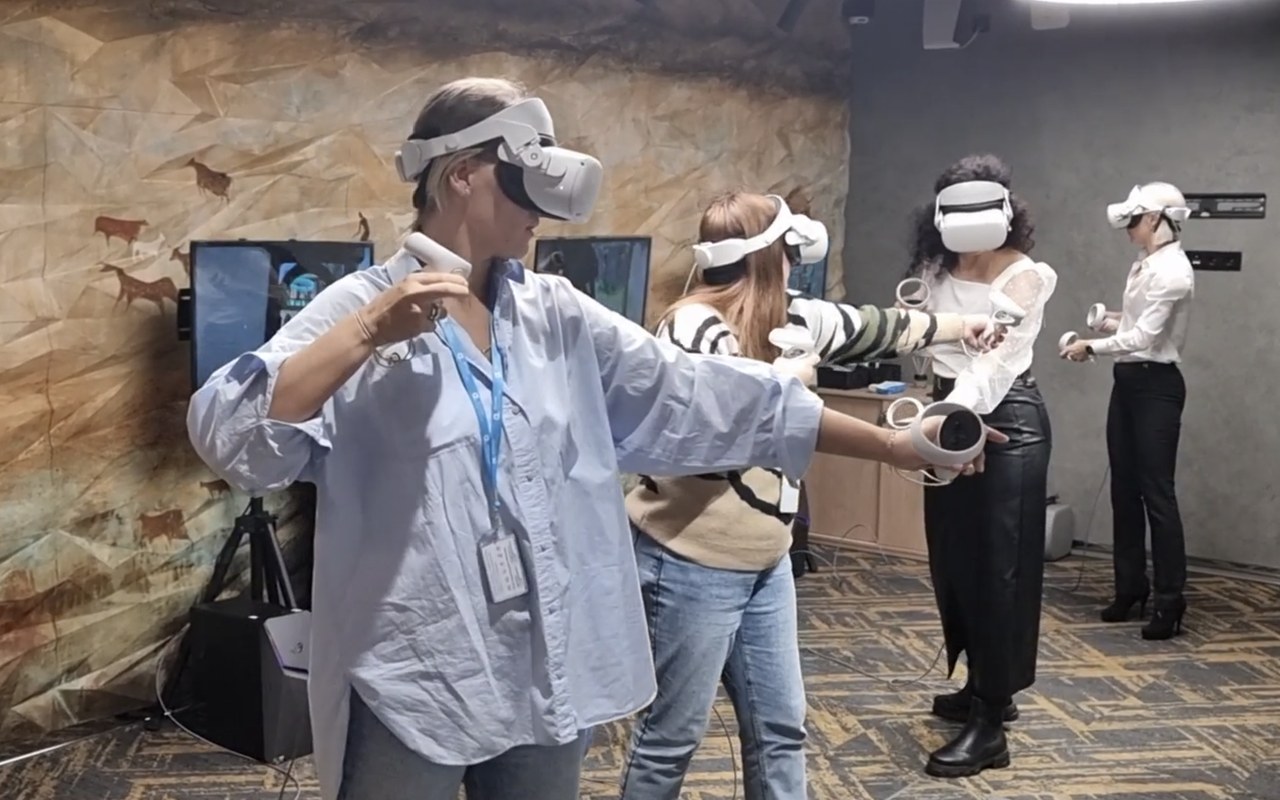 Четыре сотрудницы в VR-шлемах играют одновременно на корпоративной площадке
